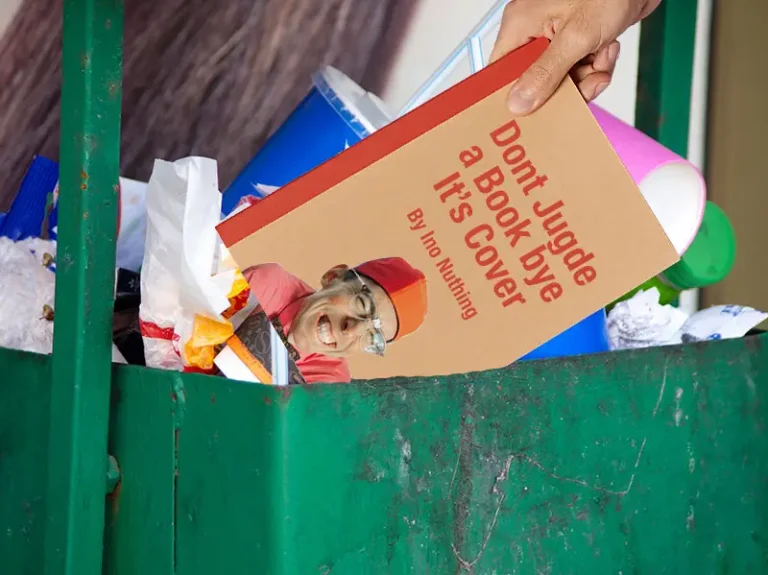 Book being dumped in a trash can.